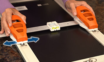 Attaching Hang Hero™ to the back of the frame and measuring